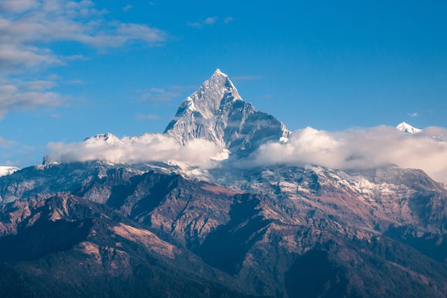 Montaña nevada en el Himalaya con nubes y cielo despejado
