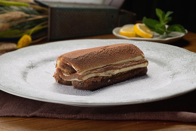 Porción de tiramisú casero sobre plato espolvoreado con azúcar impalpable