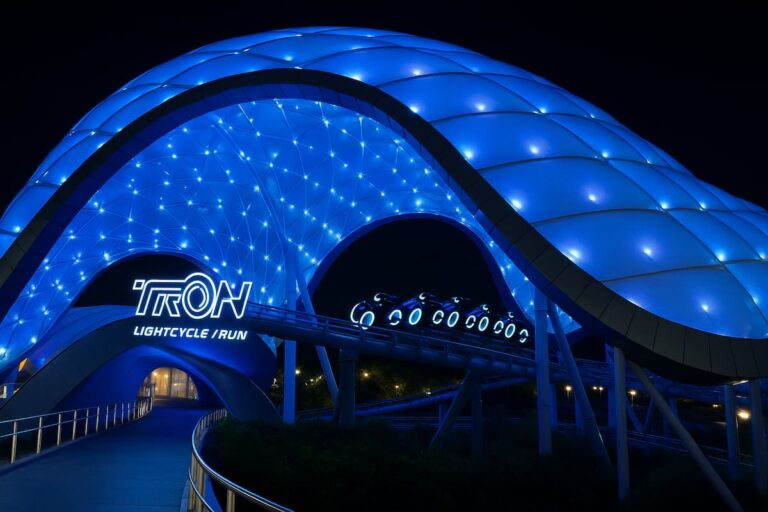 La cúpula iluminada de TRON Lightcycle Run brilla en la noche de Magic Kingdom, ofreciendo una experiencia única para los fanáticos de la velocidad y la tecnología.