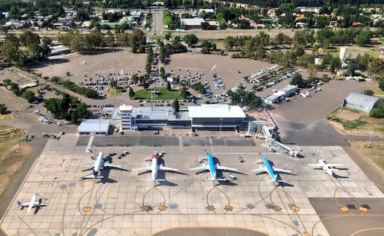 Vista aérea del aeropuerto de Neuquén con aviones en plataforma y su área terminal.