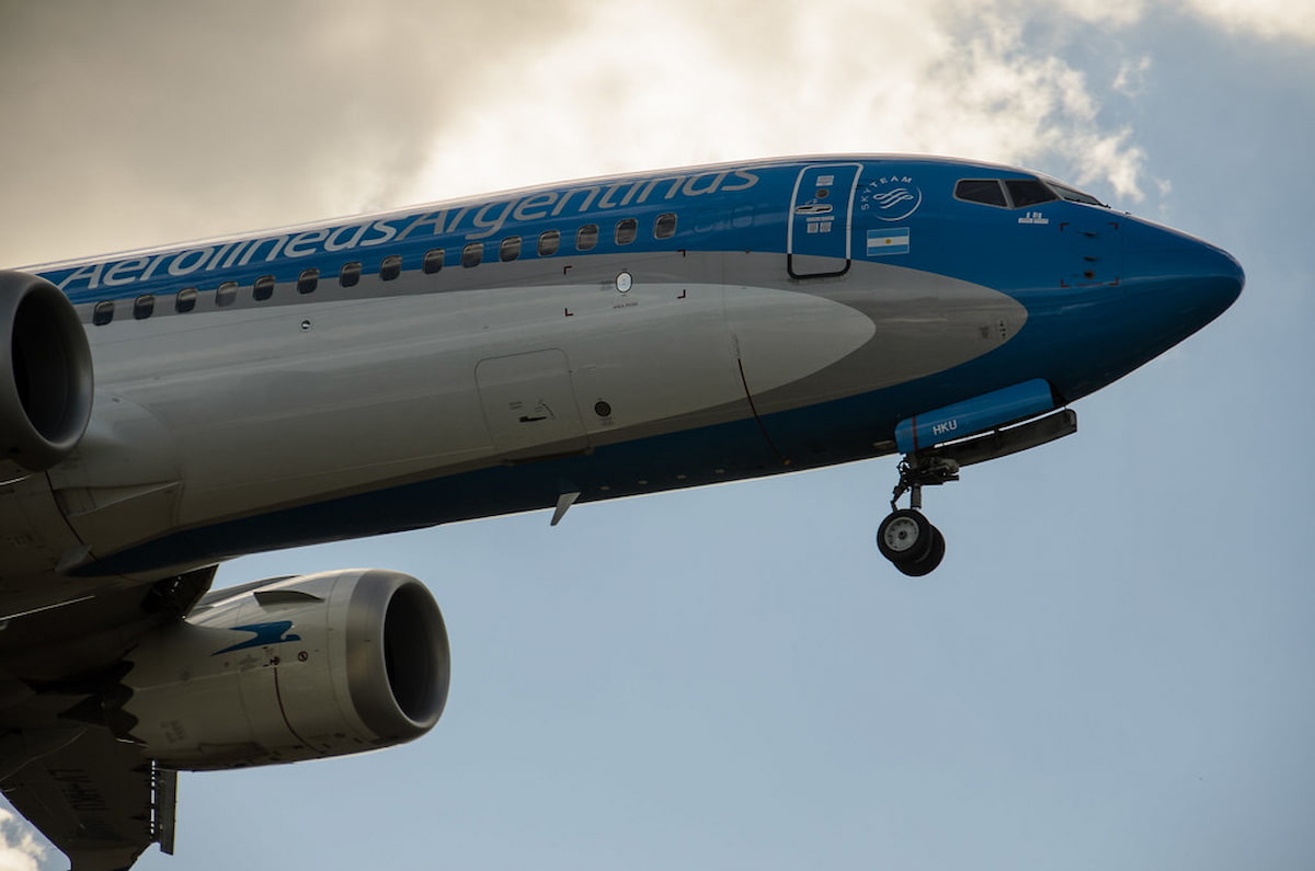Avión de Aerolíneas Argentinas despegando, con detalle del fuselaje y motor.