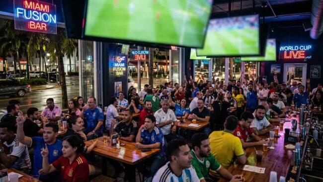 Hinchas viendo partidos del Mundial 2026 en un bar deportivo de Miami con pantallas gigantes