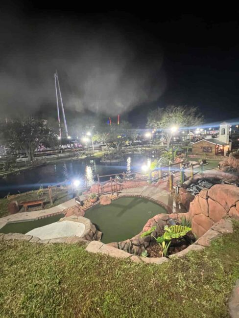 Recorrido nocturno de mini golf en Pirate’s Island Golf Orlando con lagunas y ambientación pirata