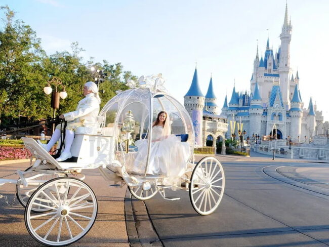 Novia llegando en carruaje estilo Cenicienta al castillo de Disney para su boda