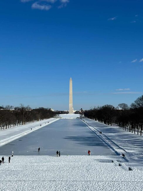 Washington Monument y el Reflecting Pool congelado cubiertos de nieve en Washington DC durante el invierno