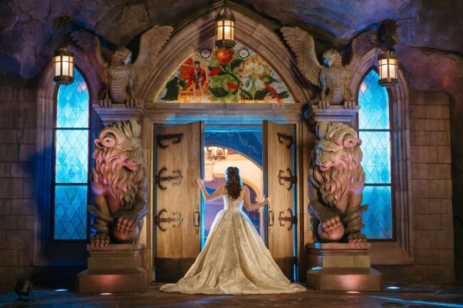 Novia con vestido de princesa entrando a escenario inspirado en Bella y la Bestia en boda temática Disney