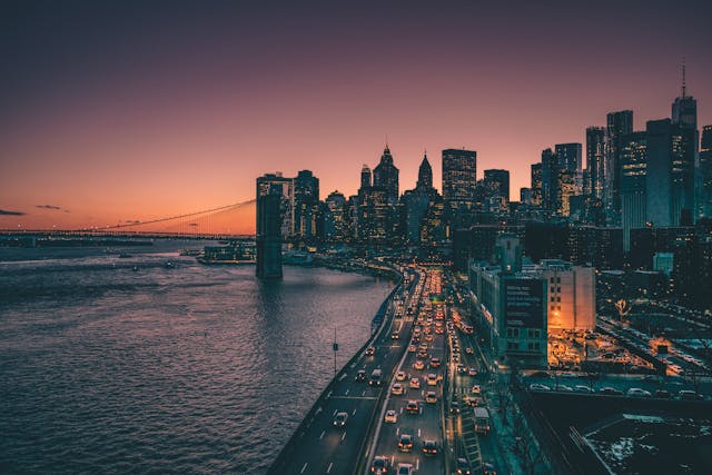 Vista del skyline de Manhattan al atardecer con tráfico junto al río, imagen representativa del costo de viajar a Nueva York desde México en 2026.
