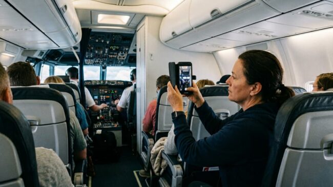 Grabar en un avión: qué está permitido y qué puede meterte en problemas Pasajera grabando dentro de un avión cerca de la cabina durante el vuelo