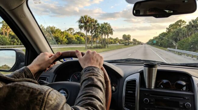 Persona conduciendo por una autopista de Florida durante un viaje en carro entre Miami y Orlando