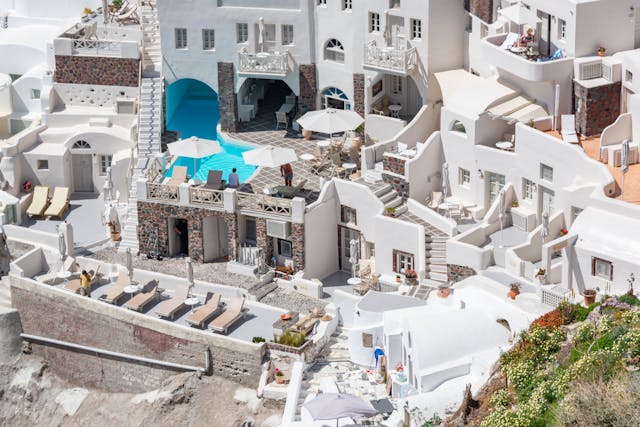 Hotel con terrazas y piscina sobre la caldera de Santorini con arquitectura blanca típica de las islas Cícladas