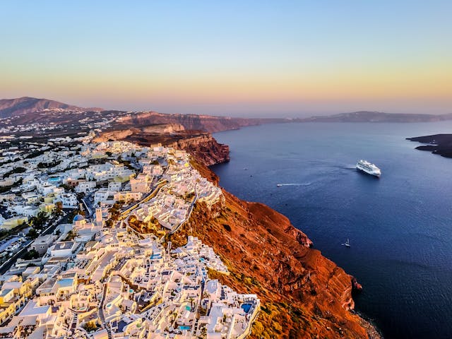 Vista aérea de Santorini con pueblos blancos sobre acantilados volcánicos frente al mar Egeo