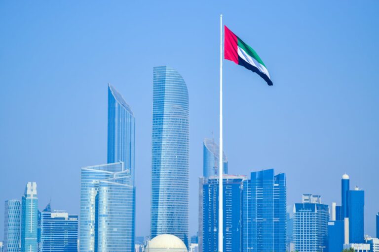 Skyline de Abu Dhabi con bandera de Emiratos &Aacute;rabes Unidos en medio de la paralizaci&oacute;n de vuelos en Medio Oriente