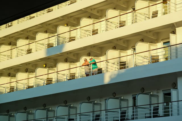 Pasajeros en cabina con balcón en un crucero, disfrutando de la vista al mar durante el viaje