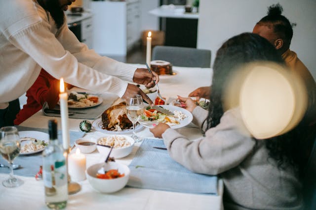 Familia compartiendo cena de Thanksgiving en casa durante Acción de Gracias en Estados Unidos.