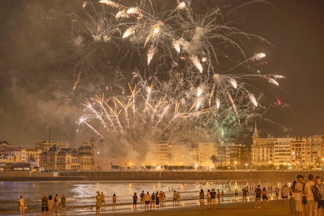 fuegos artificiales en la noche de san juan en la playa con gente mirando
