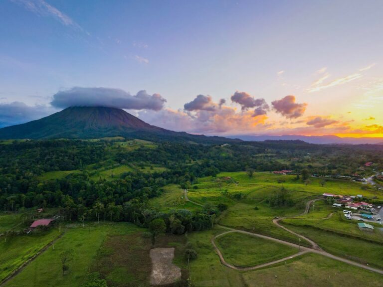 Volc&aacute;n y paisaje verde de Costa Rica al atardecer, ideal para viajar en temporada seca o de naturaleza.