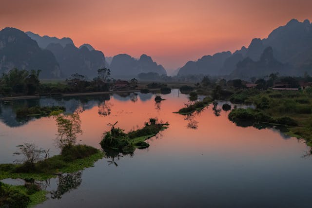 Río entre montañas kársticas de Vietnam al atardecer, paisaje ideal para viajar en temporada seca.