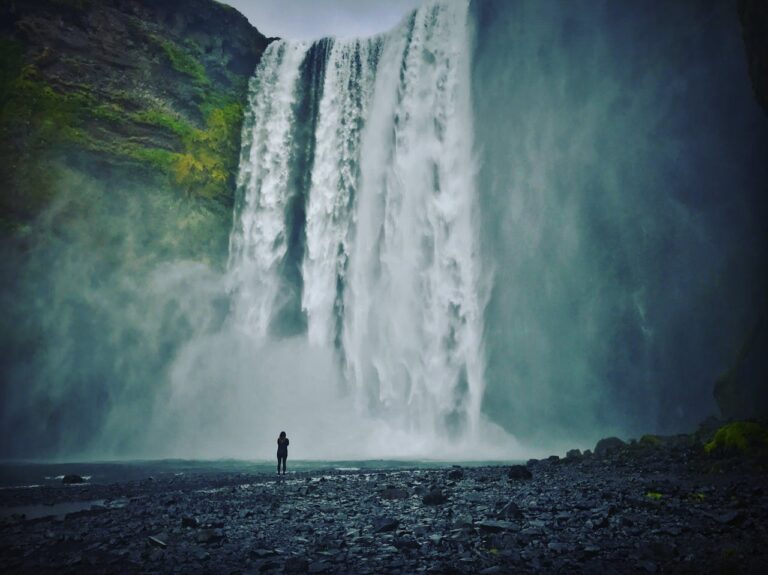 Cascada Skogafoss en Islandia con persona frente al salto de agua