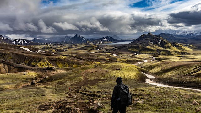 Dónde queda Islandia y por qué es un destino único para viajar Paisaje volcánico en Islandia con montañas, sendero y viajero explorando la naturaleza