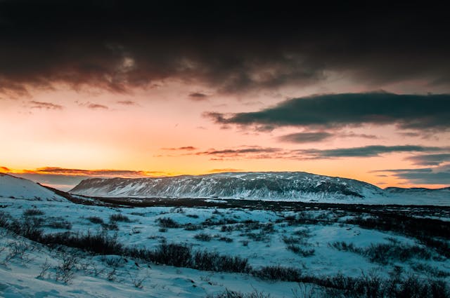 Paisaje nevado en Islandia al atardecer con montañas y clima invernal