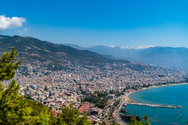 Vista costera de Alanya con playa, ciudad y montañas en Turquía.