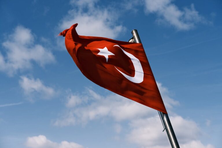 Bandera de Turqu&iacute;a ondeando al viento sobre fondo de cielo azul.