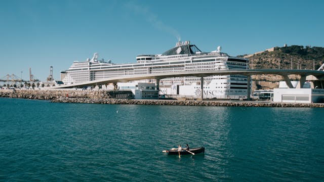 Crucero atracado en un puerto europeo junto al mar, una imagen que representa el debate sobre el turismo de cruceros y las nuevas tasas para visitantes en ciudades saturadas.