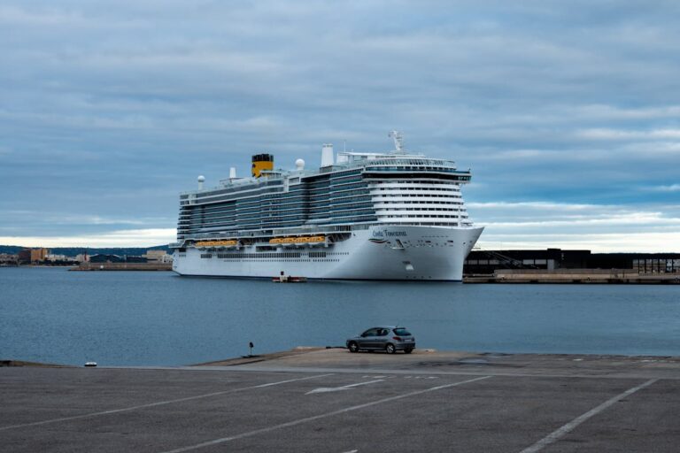 Crucero atracado en un puerto europeo bajo un cielo nublado, una imagen que representa las medidas de Barcelona para limitar el impacto del turismo de cruceros y cobrar una nueva tasa a visitantes.