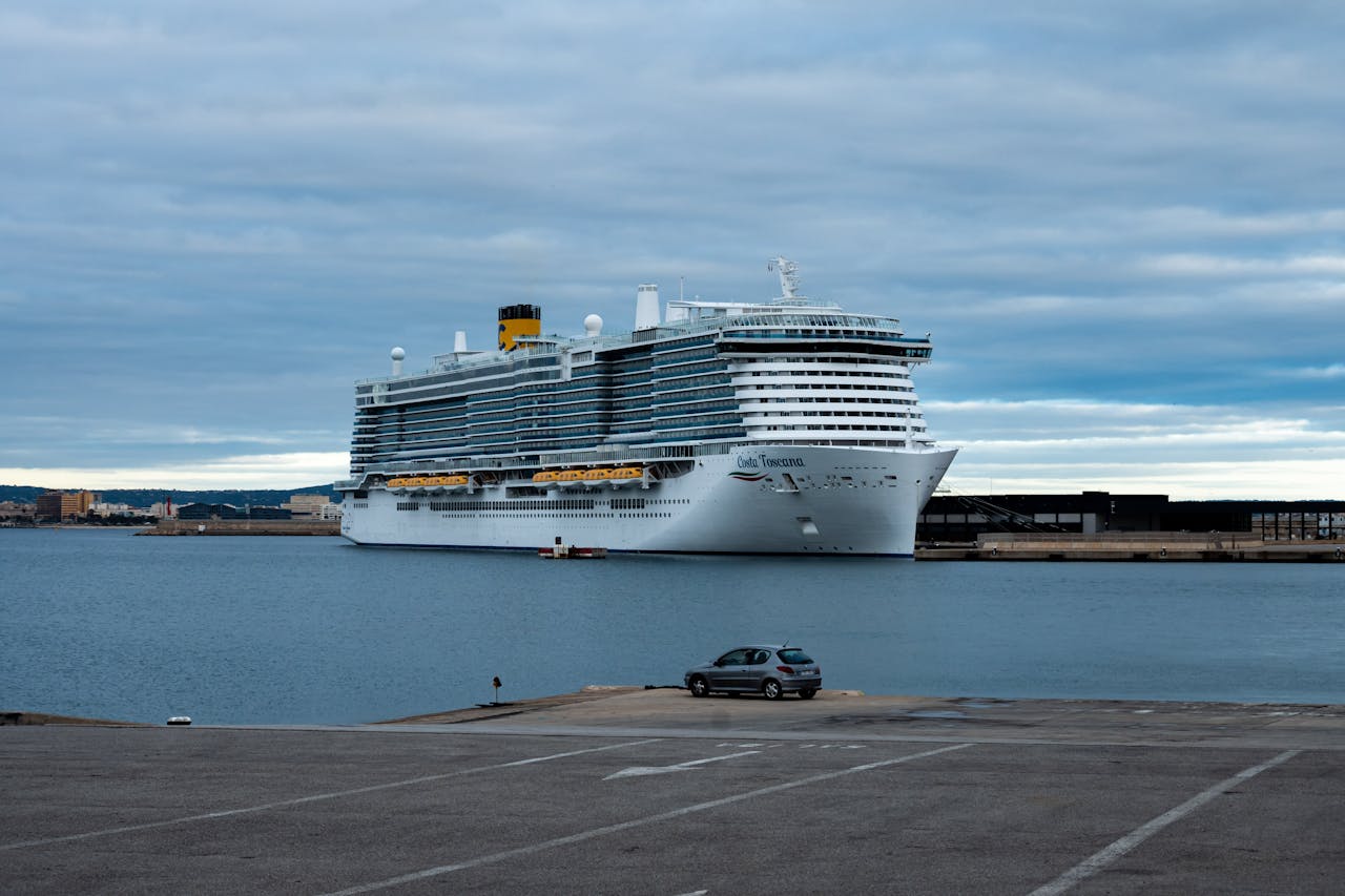 Crucero atracado en un puerto europeo bajo un cielo nublado, una imagen que representa las medidas de Barcelona para limitar el impacto del turismo de cruceros y cobrar una nueva tasa a visitantes.