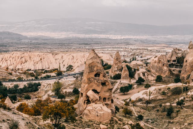 Paisaje de Capadocia con formaciones rocosas y viviendas excavadas en piedra.