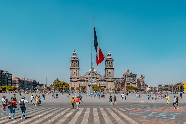 Personas caminando por el Zócalo de Ciudad de México frente a la Catedral Metropolitana, una zona turística ideal para recorrer a pie.