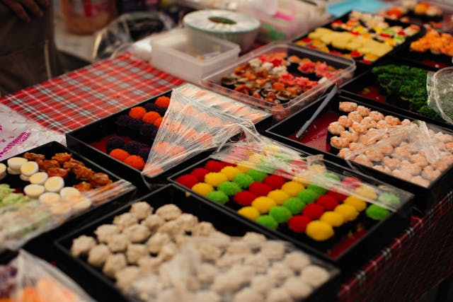 Dulces y productos de comida japonesa exhibidos en un mercado, una imagen útil para una guía de presupuesto de viaje a Japón.
