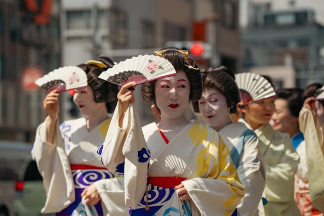 Mujeres con vestimenta tradicional japonesa y abanicos, una imagen cultural para una guía sobre cuánto cuesta viajar a Japón.