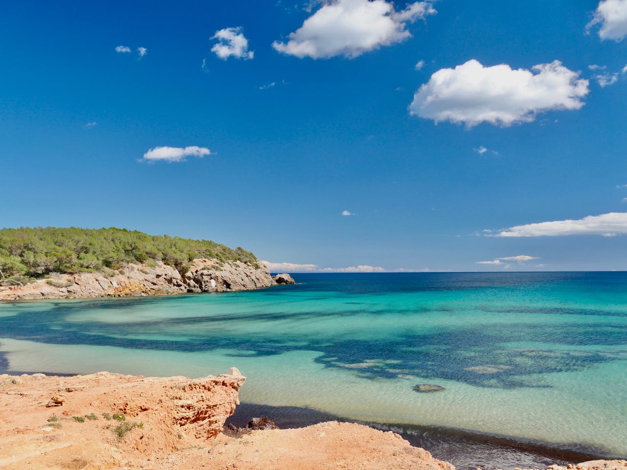 Cala de Ibiza con aguas turquesas y costa rocosa, una imagen que ayuda a ubicar la isla en el mar Mediterráneo dentro de las Islas Baleares.