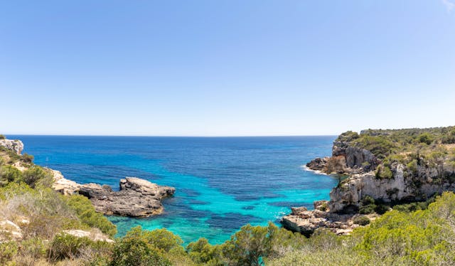 Dónde queda Ibiza: calas, ubicación y cómo llegar a la isla Cala de Ibiza con aguas turquesas, acantilados y vegetación mediterránea, una imagen que ayuda a ubicar la isla como destino de las Islas Baleares en España.