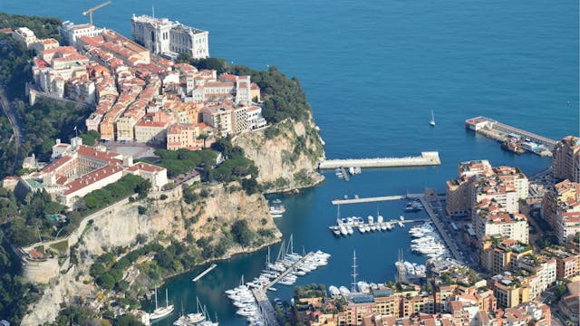 Vista aérea de Mónaco con el puerto, el mar Mediterráneo y edificios sobre la costa de la Riviera Francesa.