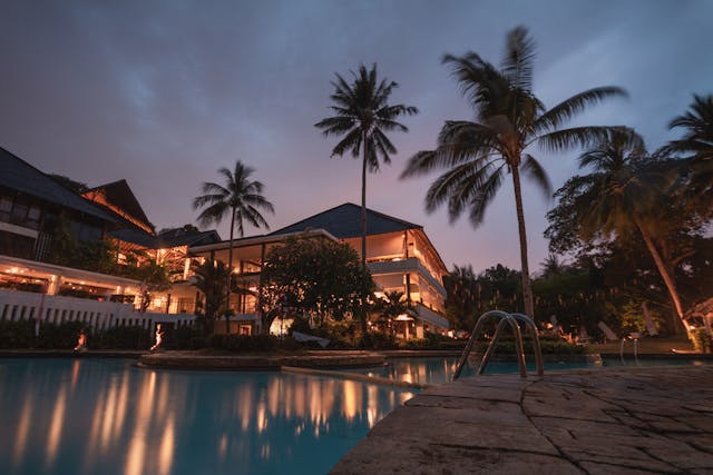 Resort de lujo con piscina, palmeras e iluminación nocturna, una imagen ideal para ilustrar los hoteles más caros del mundo en 2026 y el lujo extremo en turismo.