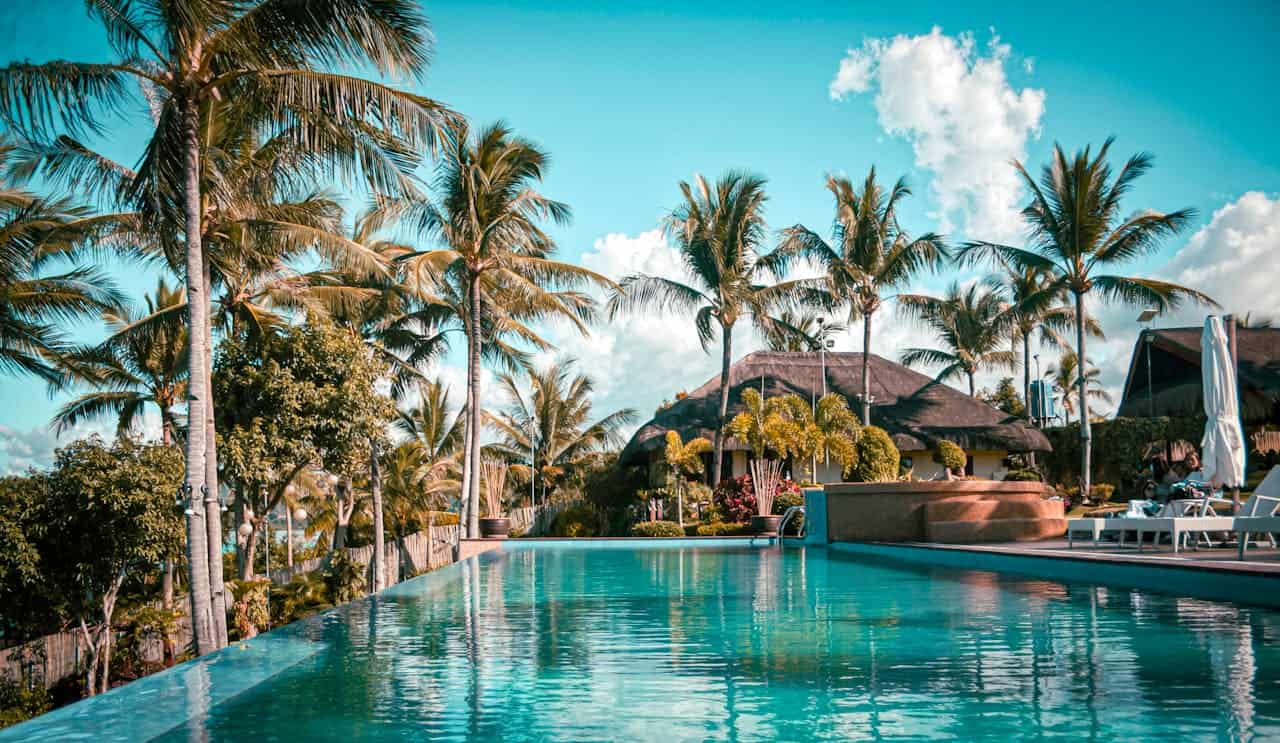 Resort de lujo con piscina infinita, palmeras y vista tropical, una imagen que representa los hoteles más caros del mundo en 2026 y las experiencias exclusivas de alto nivel.