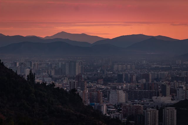 Vista panorámica de una ciudad chilena al atardecer con montañas de fondo, una imagen que representa las escapadas de invierno en Chile entre paisajes urbanos, naturaleza y cercanía a la nieve.
