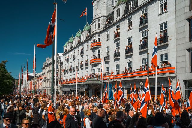 Celebración popular en Noruega con banderas nacionales, imagen relacionada con una nota sobre la altura media de los noruegos.