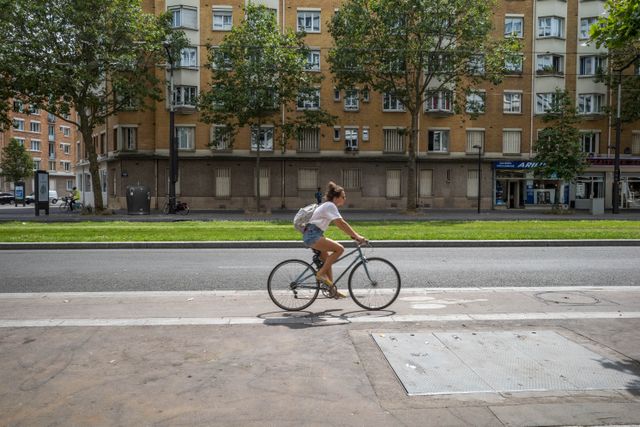 Mujer circula en bicicleta por una ciclovía urbana, una escena común en ciudades preparadas para moverse sobre dos ruedas.