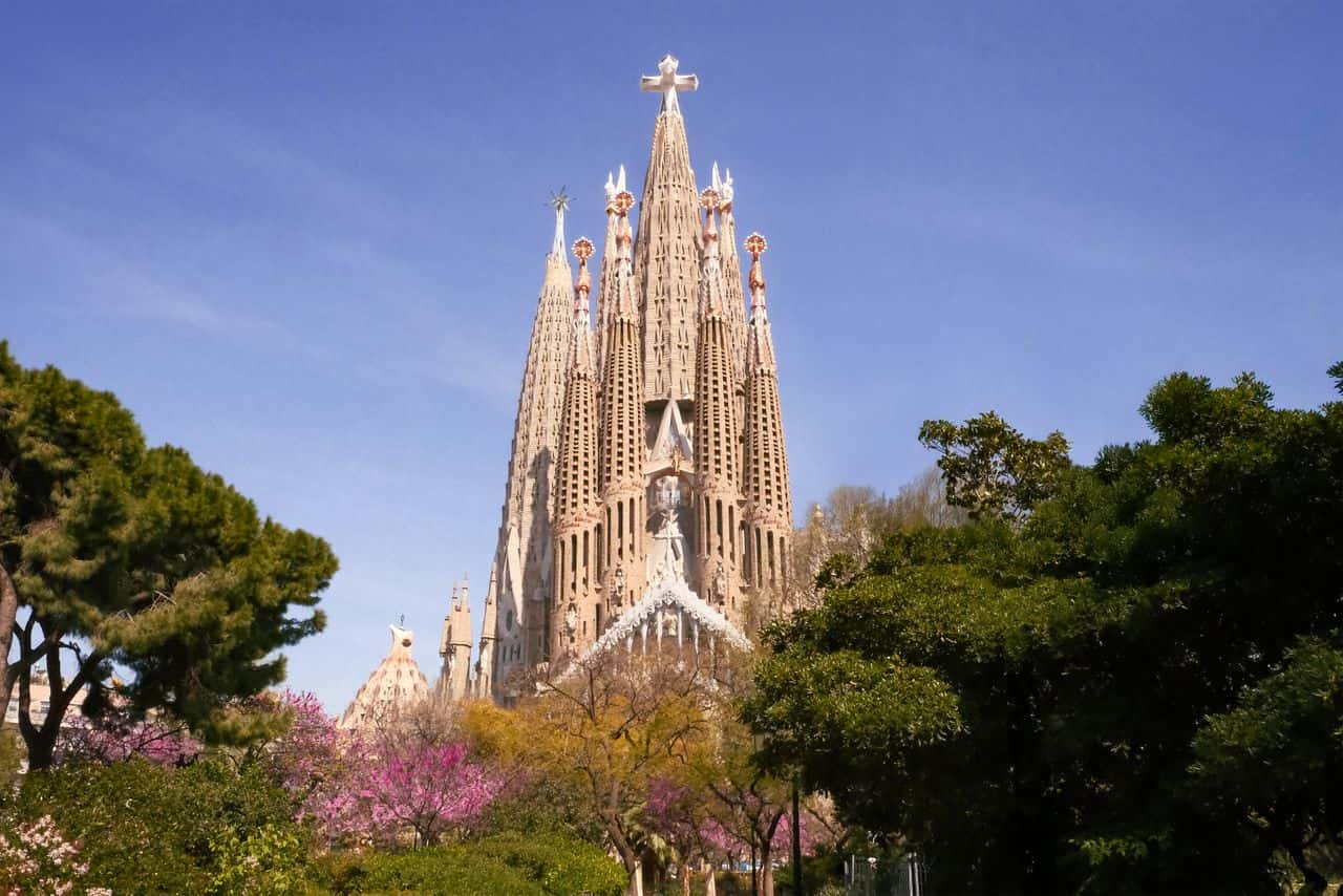 Vista de la Sagrada Familia en Barcelona rodeada de árboles, una de las visitas principales para calcular el presupuesto del viaje.