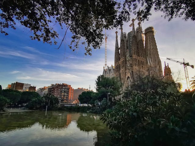 Vista de la Sagrada Familia en Barcelona desde un parque, una de las atracciones principales para incluir en el presupuesto del viaje.