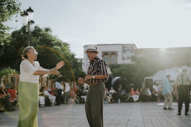 Personas mayores bailando en una plaza al aire libre, una escena asociada a destinos con cultura, vida local y bajo costo para jubilados.