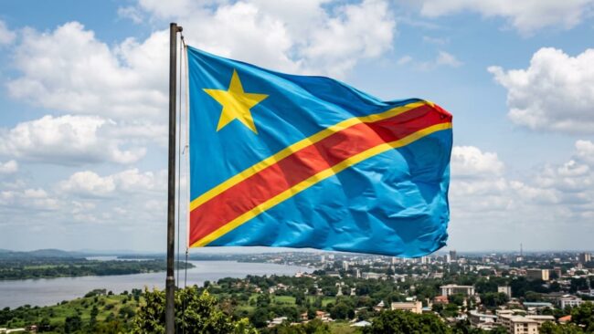 Bandera de la Rep&uacute;blica Democr&aacute;tica del Congo ondeando sobre una ciudad, imagen relacionada con una gu&iacute;a sobre d&oacute;nde queda Congo.