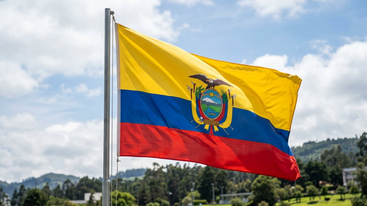 Bandera de Ecuador ondeando frente a un paisaje verde, imagen relacionada con una guía sobre dónde queda Ecuador y cómo llegar.