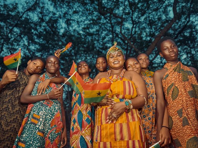 Cultura de Ghana y bandera del país Grupo de personas con vestimenta tradicional y banderas de Ghana, imagen relacionada con una guía sobre dónde queda Ghana y qué saber antes de viajar.