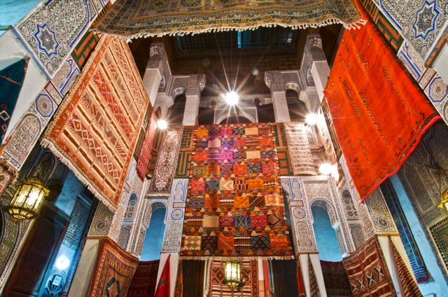 Interior tradicional en Marruecos con alfombras, azulejos y arquitectura decorada, imagen relacionada con qué ver en el país.