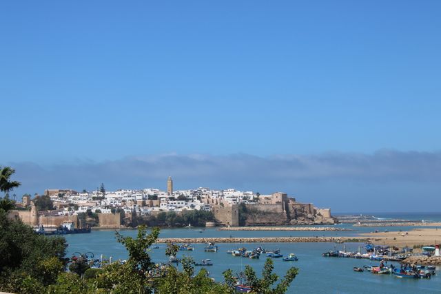 Vista de Rabat, capital de Marruecos, junto al océano Atlántico, con murallas, barcos y edificios blancos.