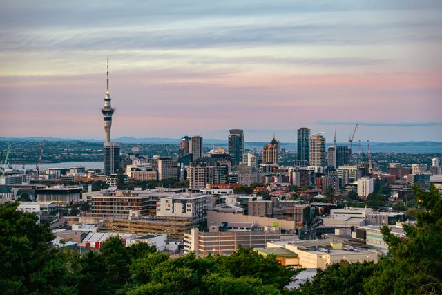 Vista panorámica de Auckland en Nueva Zelanda, con la Sky Tower, edificios modernos y la bahía al fondo.